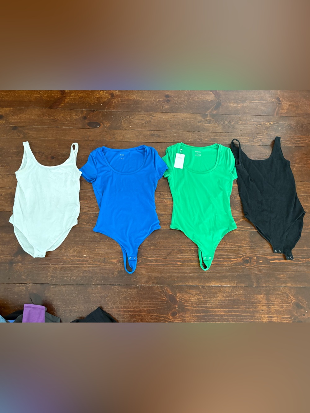 One-Piece Bodysuits in White, Blue, Green, and Black